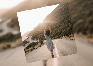 Frau läuft auf weiter Straße, freudig der Sonne entgegen. Symbolisiert Freihiet
